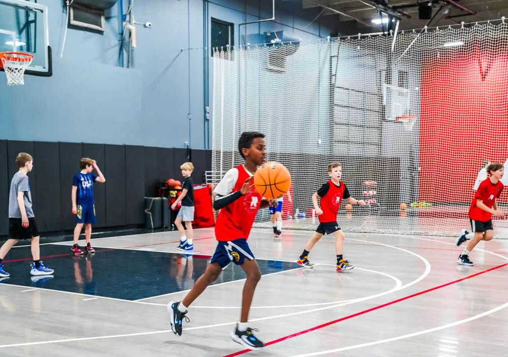elementary boys basketball player dribbling basketball