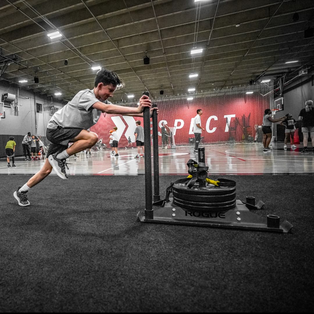 youth athlete pushing weighted sled