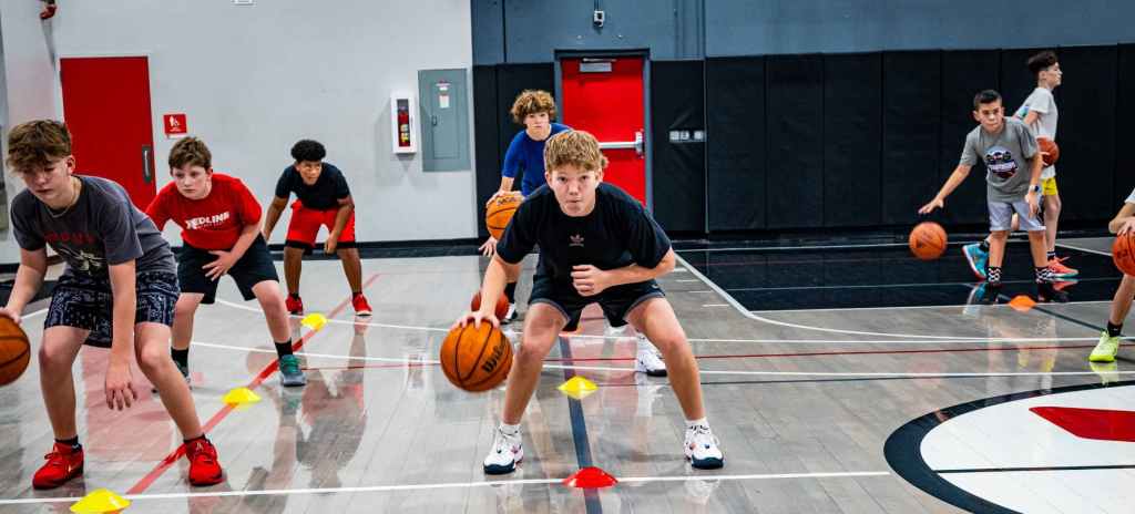 athletes dribbling in front of cones