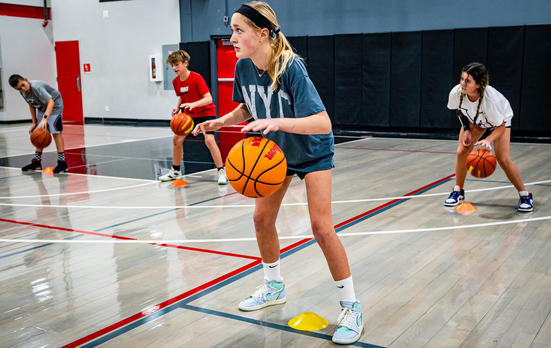 girls basketball player dribbling over a cone