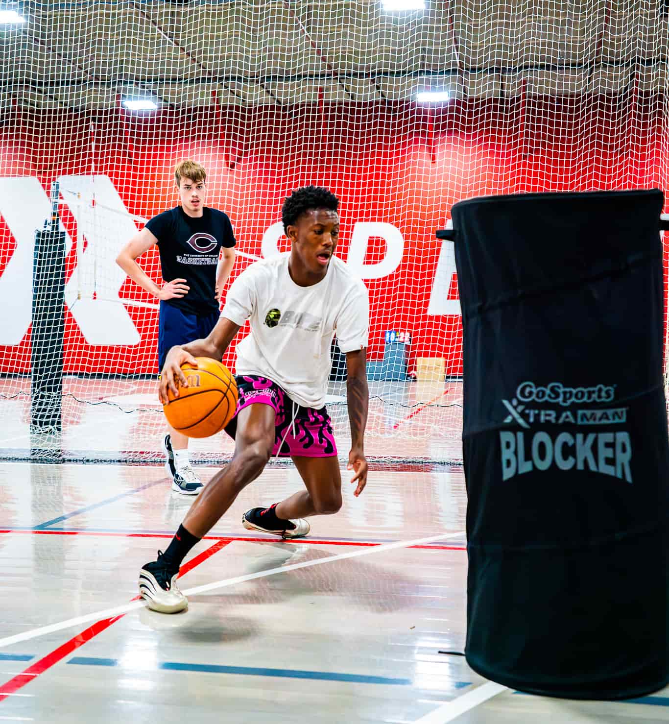 high school basketball player dribbling around a cone