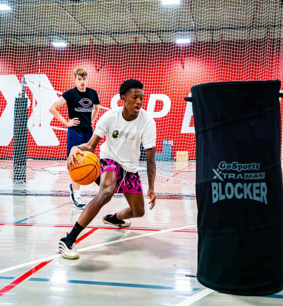 high school basketball player dribbling around a cone