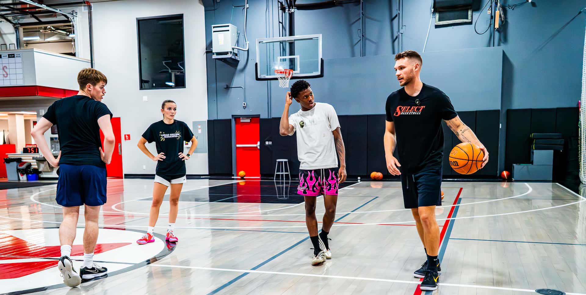 coach brandon works with three teen athletes