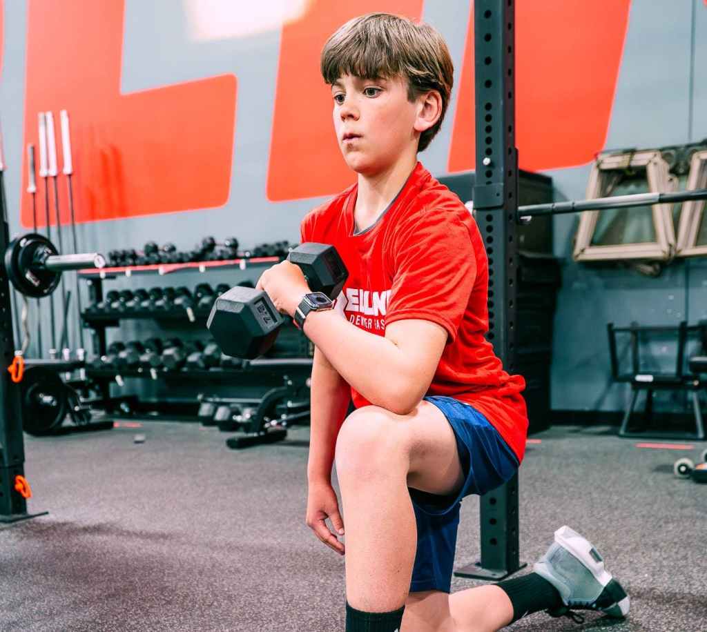 youth boy lifting dumbbells