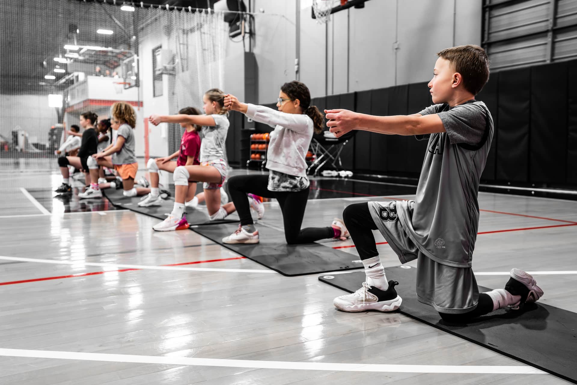 boys and girls volleyball players kneel during drill
