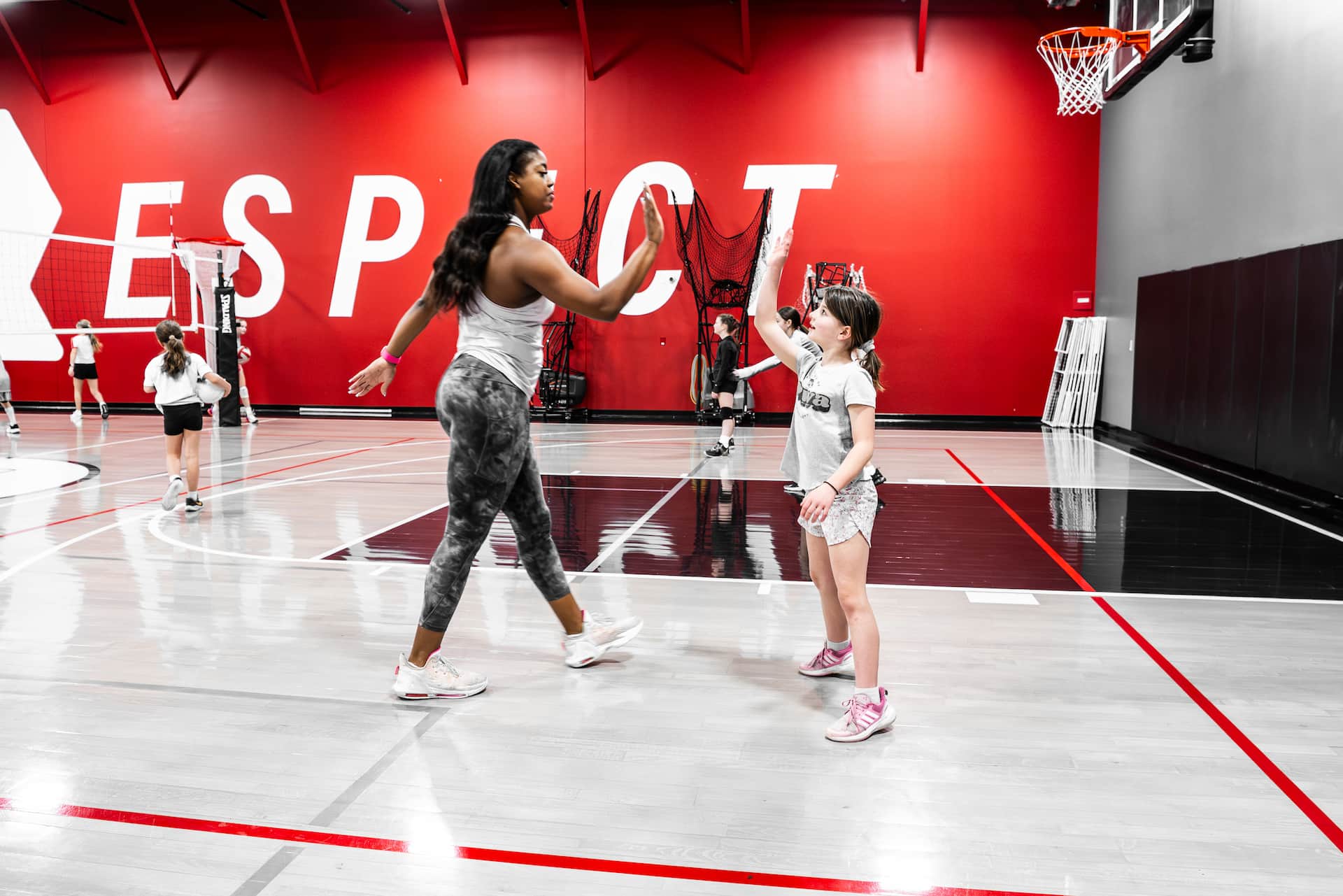 coach jenelle high fiving a volleyball athlete