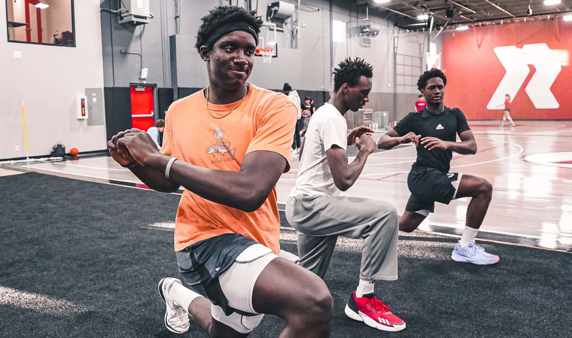three mens basketball players stretching