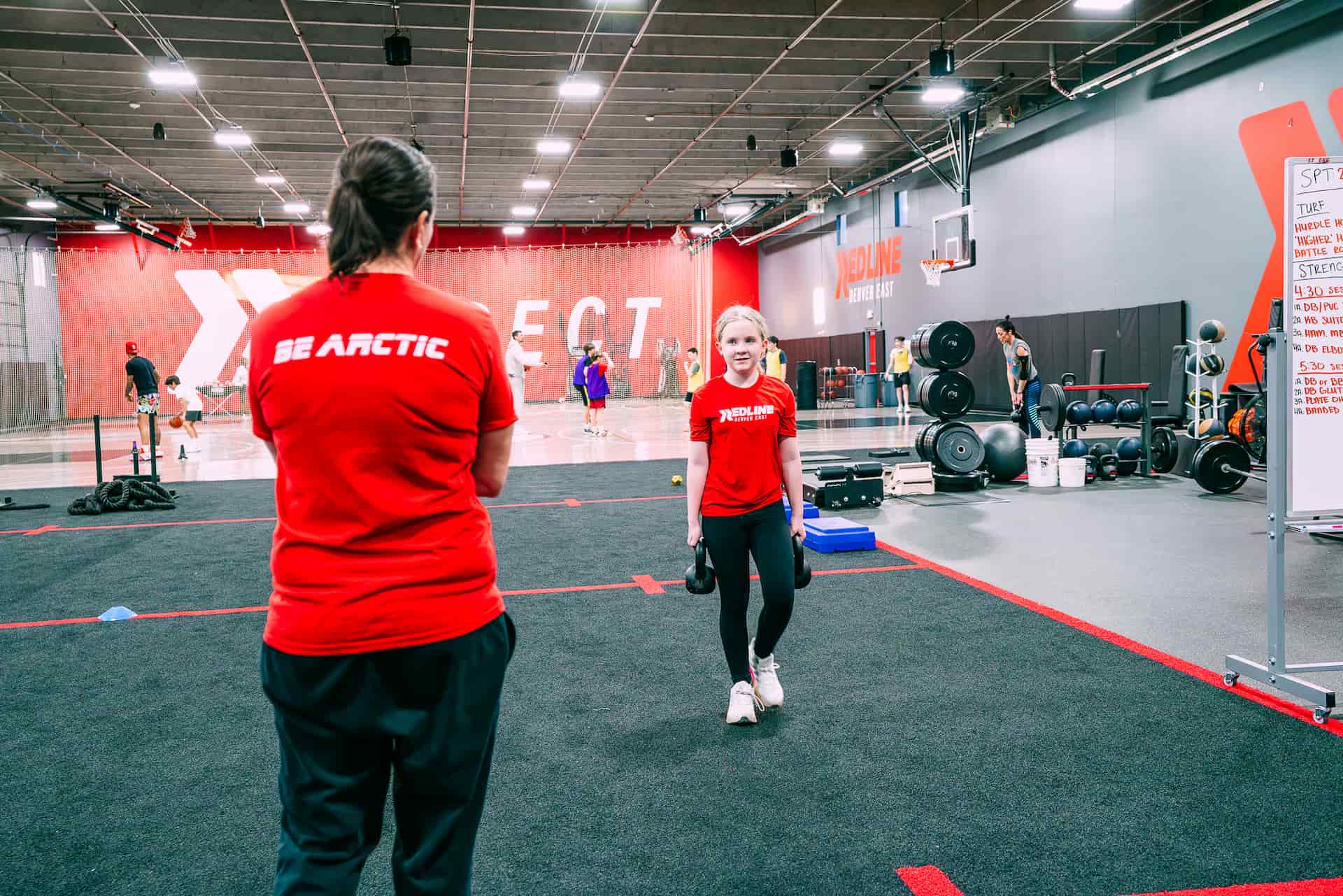 athlete carrying weights talking with coach